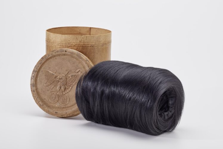 Hersteller unbekannt, Affenfell-Muff in originaler Schachtel, 1870–1873, Muff: Affenfell, Seide, Schachtel: Karton, teilweise geprägt, Papier, bedruckt, 20 x 22,5 cm, Inv.-Nr. 2003-2023 © Salzburg Museum (Schenkung 2023)